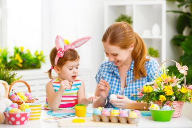 mutlu aile anne ve çocuk kız yumurta Paskalya için boyar.