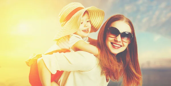 Happy family mother and child daughter on beach at sunset — Stock Photo, Image