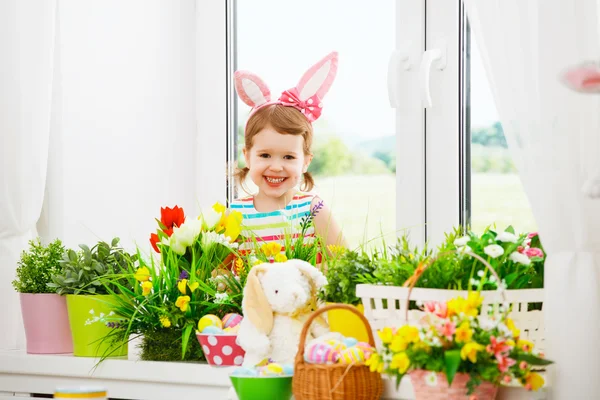 Semana Santa. niña feliz con orejas de conejo y huevos coloridos sitti — Foto de Stock