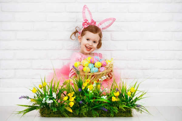 Feliz chil en traje de conejo de Pascua con huevos y hierba verde ingenio — Foto de Stock