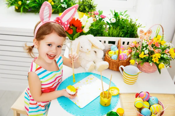 Happy child girl paints eggs for Easter — Stock Photo, Image