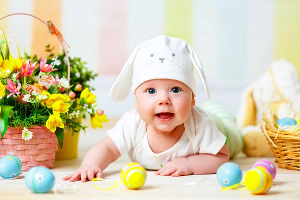 Criança bebê feliz com orelhas de coelho de Páscoa e ovos e flores — Fotografia de Stock