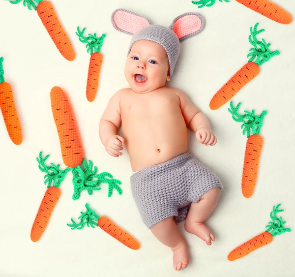 Ευτυχισμένο μωρό παιδί στο κοστούμι bunny κουνέλι με καρότο σε ένα μόριο — Φωτογραφία Αρχείου