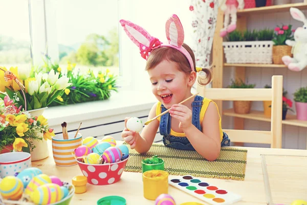 Menina feliz pinta ovos para a Páscoa — Fotografia de Stock