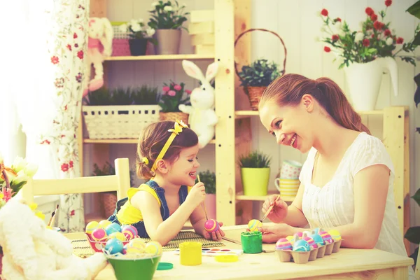 Feliz familia madre e hijo niña pinta huevos para Pascua — Foto de Stock