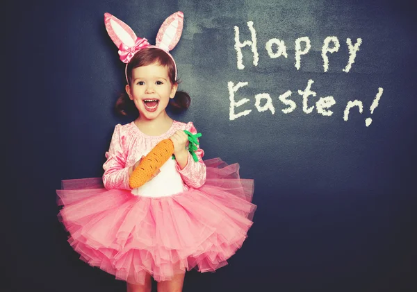 Feliz Páscoa! menina no traje coelho com cenoura sobre bla — Fotografia de Stock