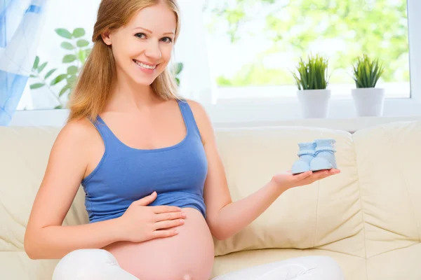 Glücklich schwangere Frau ruht zu Hause auf dem Sofa und hält ein bl — Stockfoto