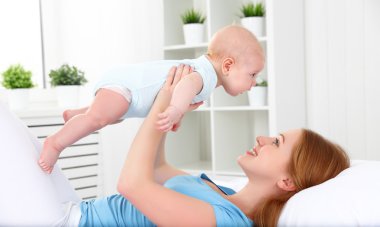 mutlu aile anne bebek yatakta ile oynarken