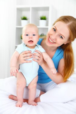 mutlu aile anne bebek yatakta ile oynarken