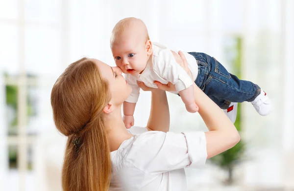 Happy family mother  throws up child baby at home Stock Image