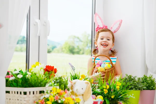 Semana Santa. niña feliz con orejas de conejo y huevos coloridos sitti — Foto de Stock