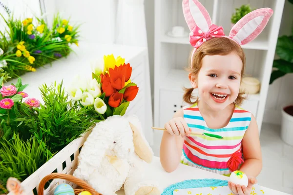 Šťastné dítě dívka maluje vajíčka na Velikonoce — Stock fotografie