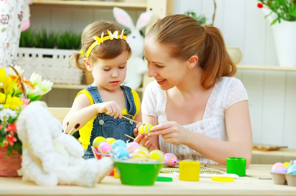 Feliz familia madre e hijo niña pinta huevos para Pascua —  Fotos de Stock