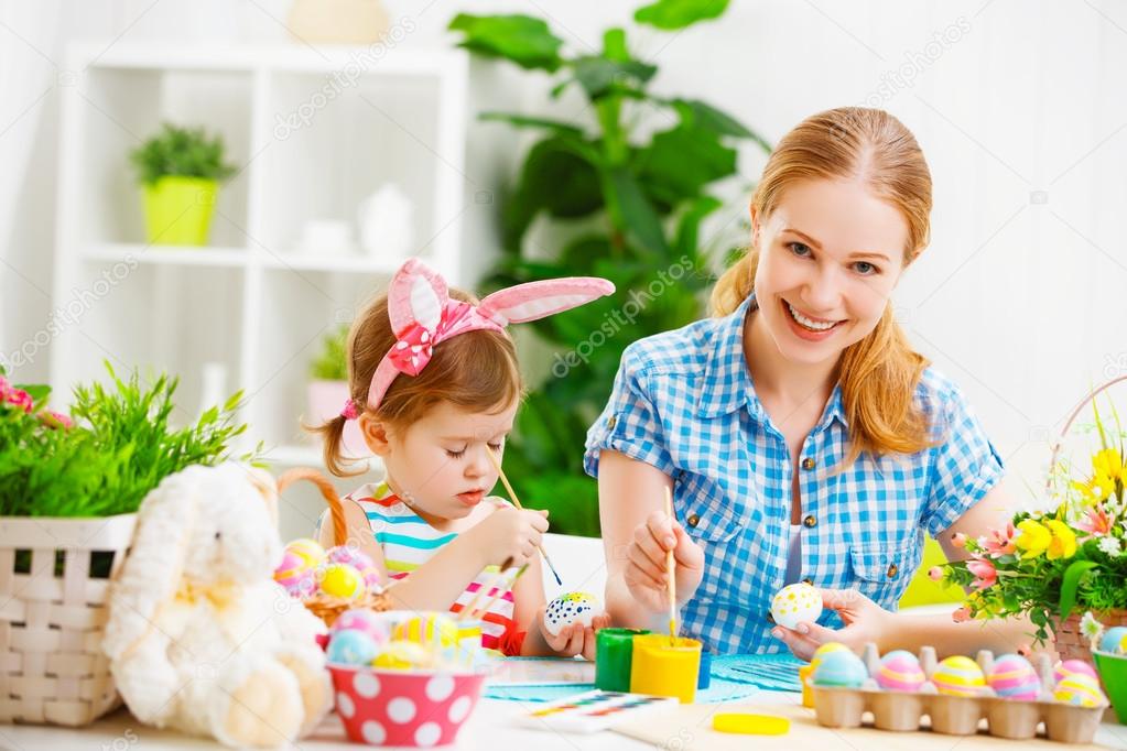 happy family mother and child girl paints eggs for Easter