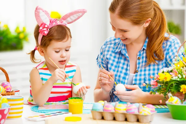 Feliz familia madre e hijo niña pinta huevos para Pascua —  Fotos de Stock