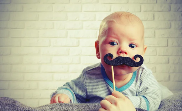 Bebê engraçado com um bigode — Fotografia de Stock