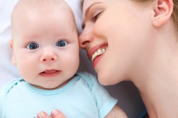 Feliz familia madre besos y abrazos su bebé — Foto de Stock