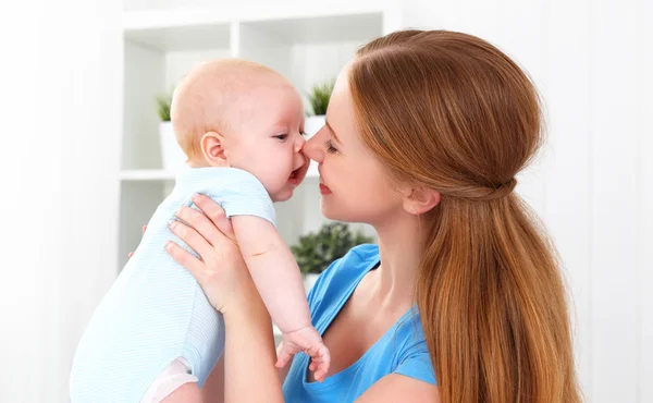 Feliz familia madre jugando con el bebé en la cama — Foto de Stock