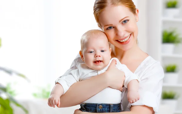 Gelukkige familie moeder haar baby knuffelen — Stockfoto