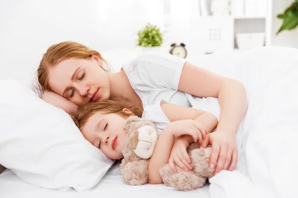 Счастливая семья матери и ребенка, спящего в постели — стоковое фото