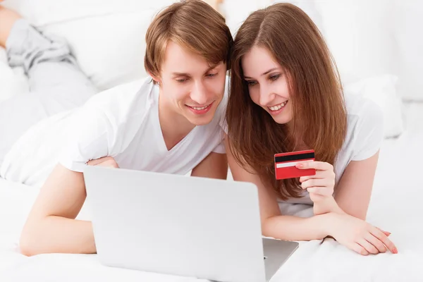 Casal feliz faz compras on-line com laptop e cartão de crédito um — Fotografia de Stock