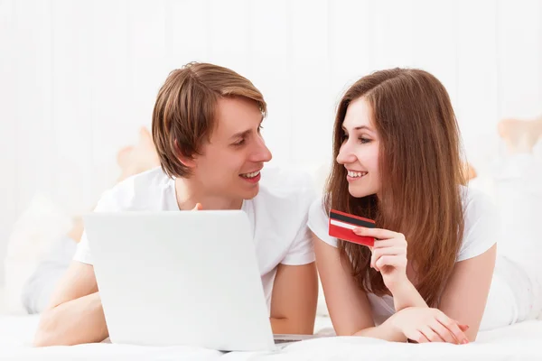 Casal feliz faz compras on-line com laptop e cartão de crédito um — Fotografia de Stock