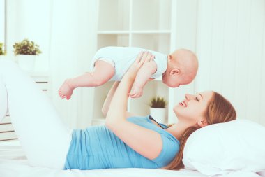mutlu aile anne bebek yatakta ile oynarken