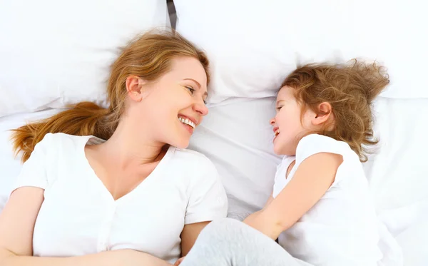 快乐家庭的母亲和孩子玩、 笑着躺在床上 — 图库照片