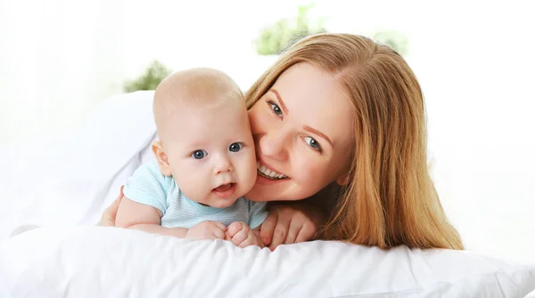 Gelukkige familie moeder met baby in bed — Stockfoto