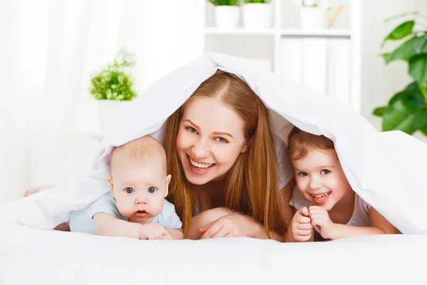 Boldog család anya és a két gyermek, a fiú és a leány, a bed ENSZ — Stock Fotó