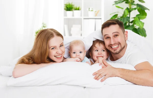 Família feliz em casa na cama — Fotografia de Stock