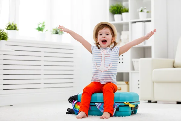 Criança feliz menina embala roupas em mala para viajar, vacatio — Fotografia de Stock