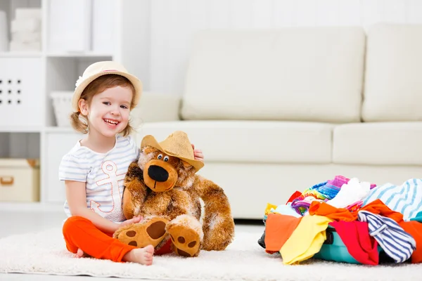 Gelukkig kind meisje verzamelen koffer op vakantie — Stockfoto