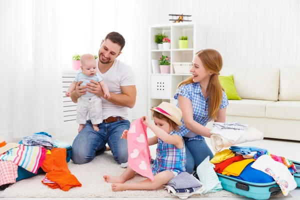 Gelukkige familie moeder, vader en twee kinderen verpakt koffers fo — Stockfoto