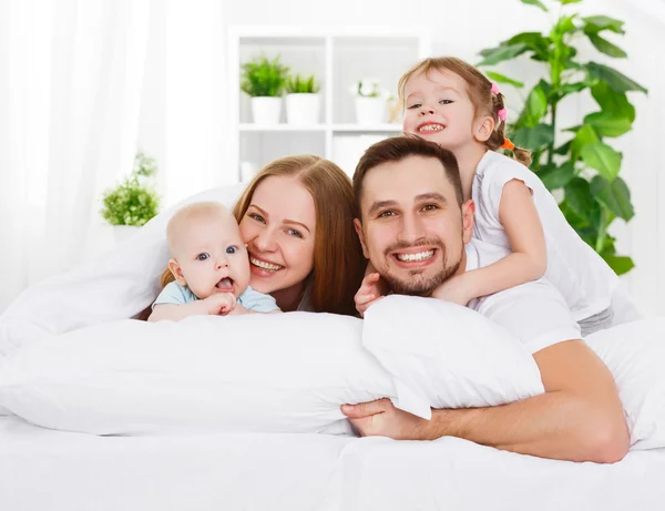 Šťastná rodina doma v posteli — Stock fotografie