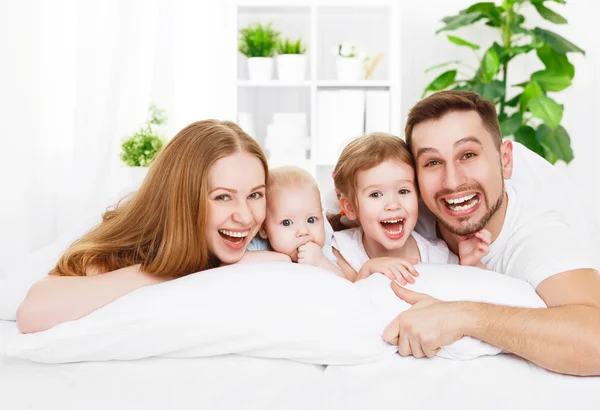 Familia feliz en casa en la cama — Foto de Stock