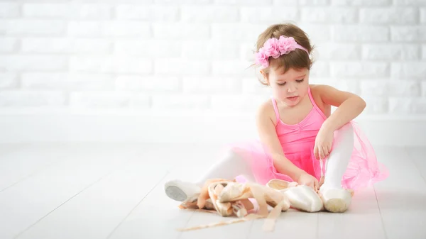 Little child girl dreams of becoming  ballerina with ballet shoe — Stock Photo, Image