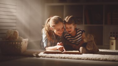 mutlu aile anne ve kızı akşamları bir kitap okumak