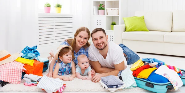 happy family mother, father and two children packed suitcases fo