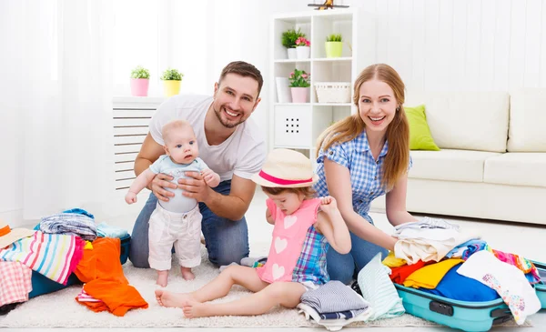 happy family mother, father and two children packed suitcases fo