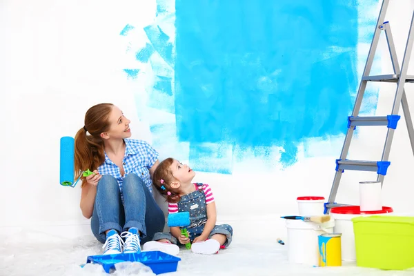 Família feliz mãe e criança filha fazendo reparos, pintura wal — Fotografia de Stock