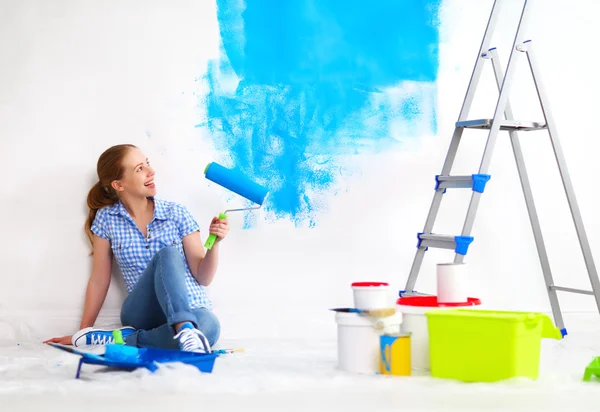 Mulher feliz fazendo reparos, parede de pintura em casa — Fotografia de Stock