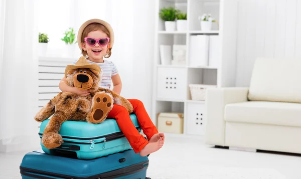 Bambina felice raccogliere valigia in vacanza — Foto Stock