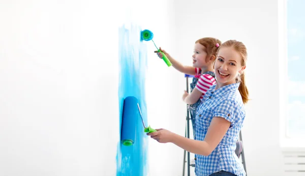 Família feliz mãe e criança filha fazendo reparos, pintura wal — Fotografia de Stock