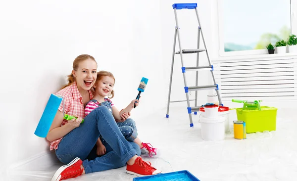 Família feliz mãe e criança filha fazendo reparos, pintura wal — Fotografia de Stock