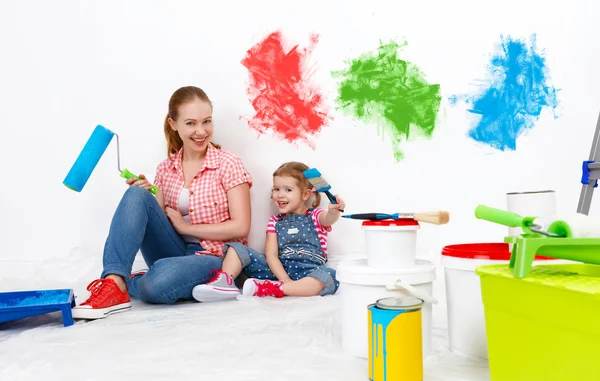 Família feliz mãe e criança filha fazendo reparos, pintura wal — Fotografia de Stock