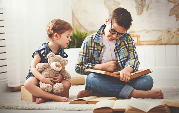 Children brother and sister, boy and girl reading a book — Stock Photo, Image