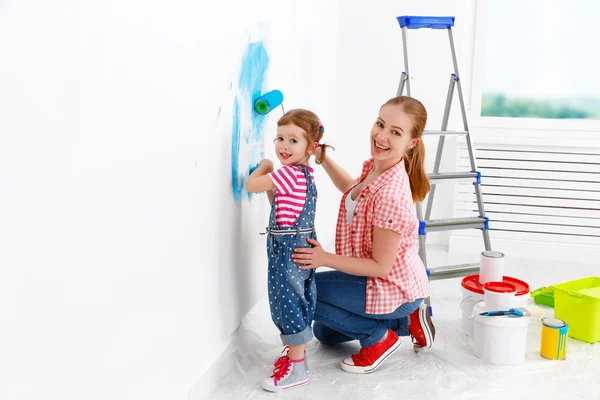 Família feliz mãe e criança filha fazendo reparos, pintura wal — Fotografia de Stock