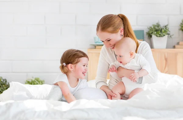 Mère de famille heureuse et deux enfants, fils et fille au lit — Photo