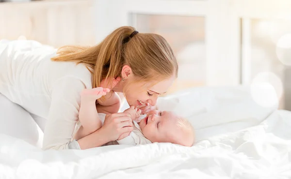 Família feliz mãe com bebê na cama — Fotografia de Stock